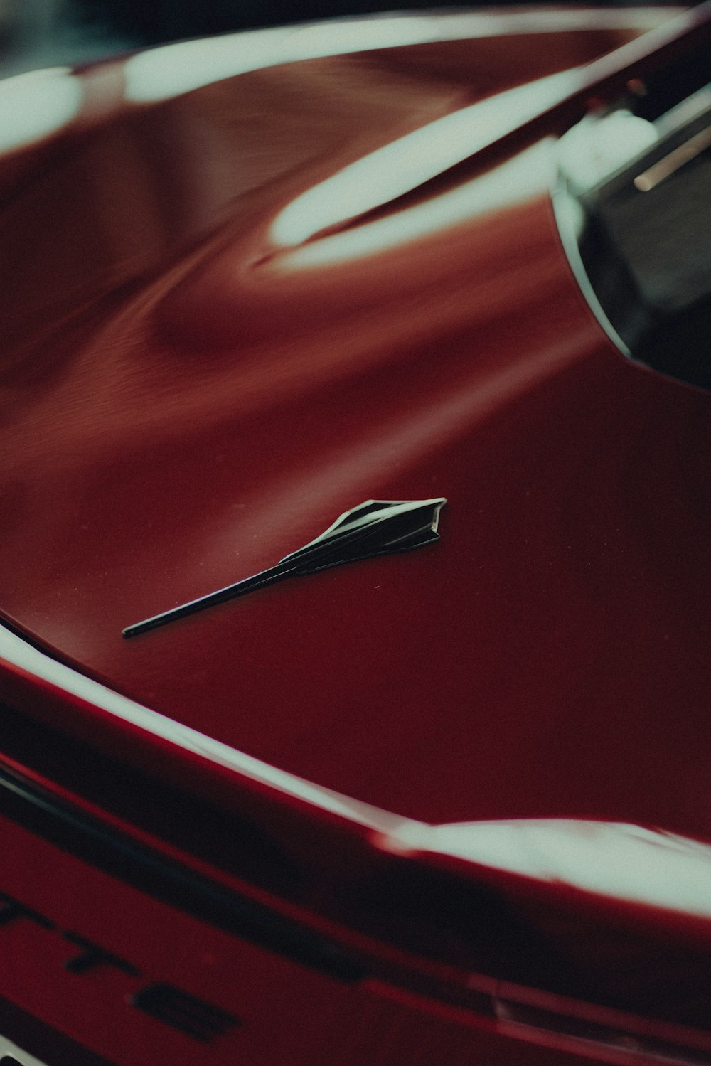 a close up of the hood of a red car