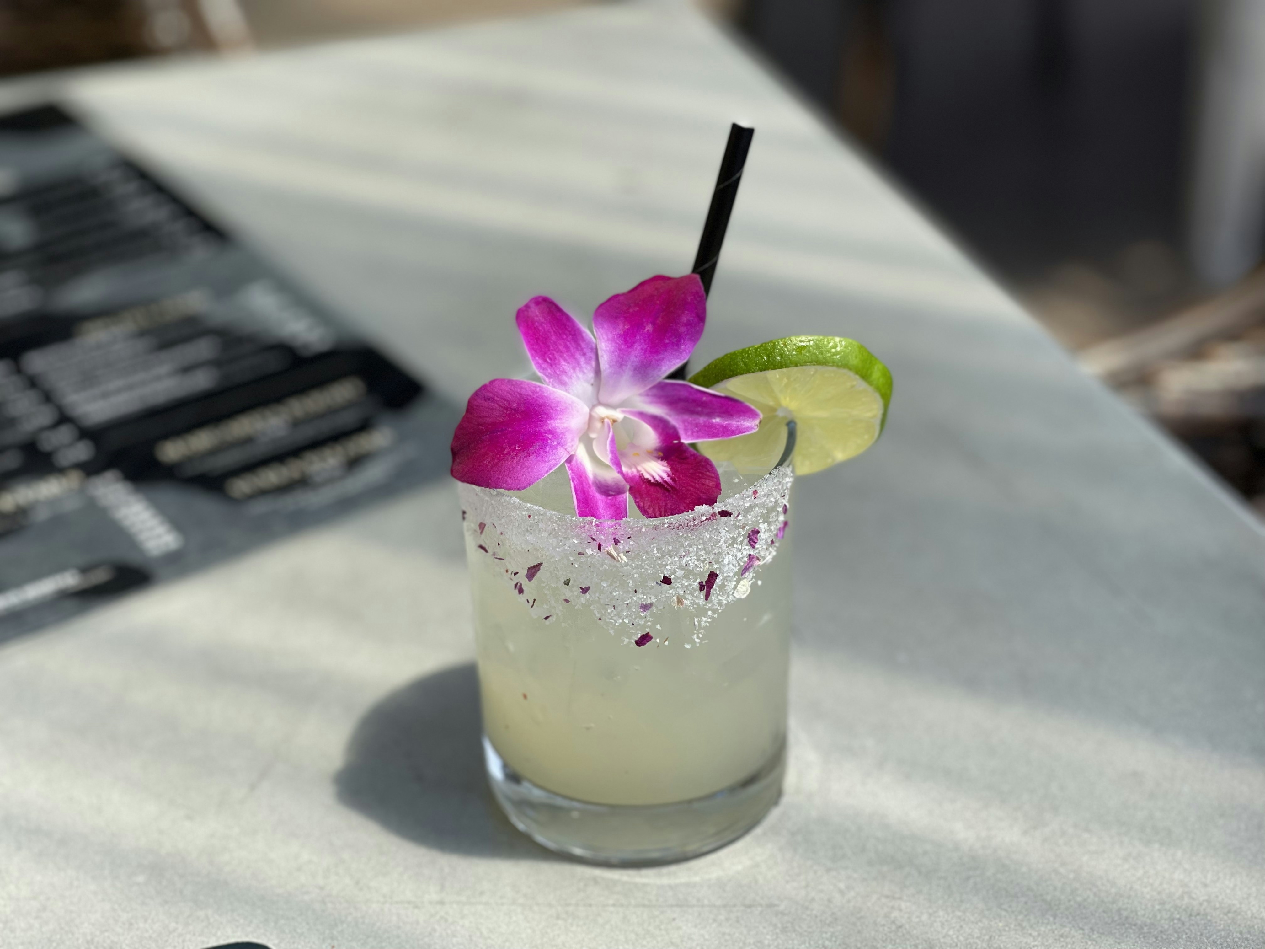 a drink with a purple flower on the rim