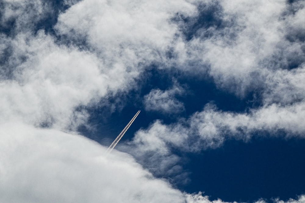 a plane is flying through the cloudy sky