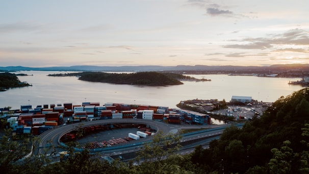 A sunset view over a sprawling container yard with rows of containers stretching into the distance.