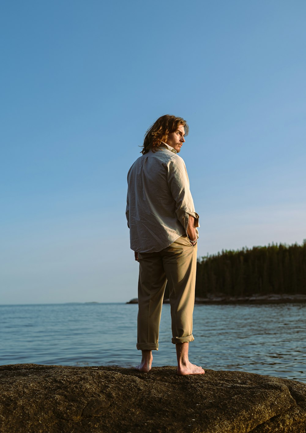 a person standing on a rock by the water