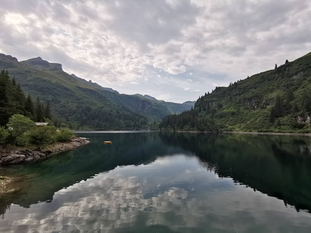 uno specchio d'acqua circondato da montagne e alberi