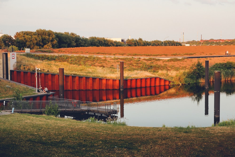 a body of water with a red fence next to it