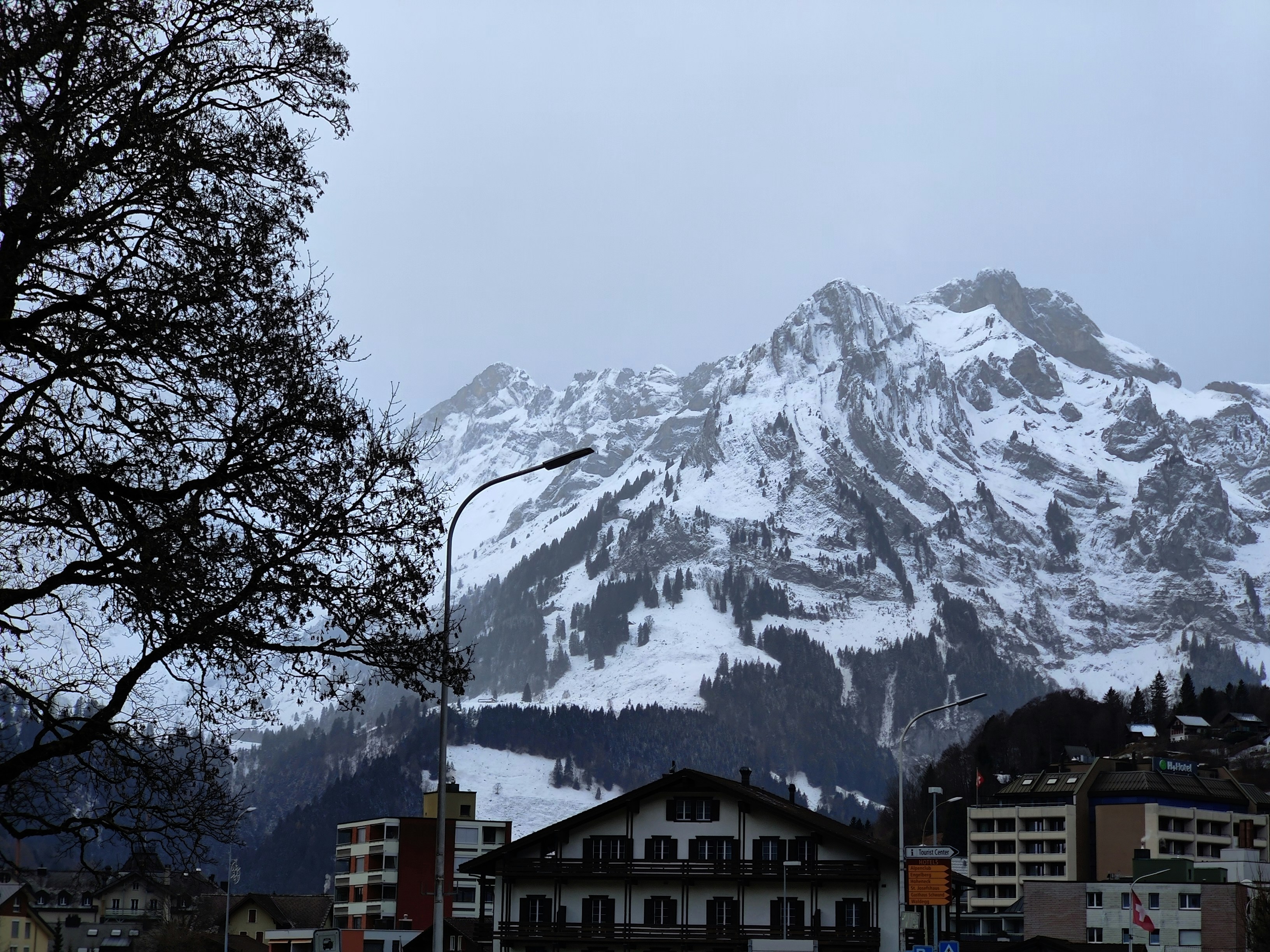 a snow covered mountain towering over a city