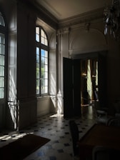 Elegant living room showcasing flawless custom hardwood flooring with soft sunlight streaming through large windows.