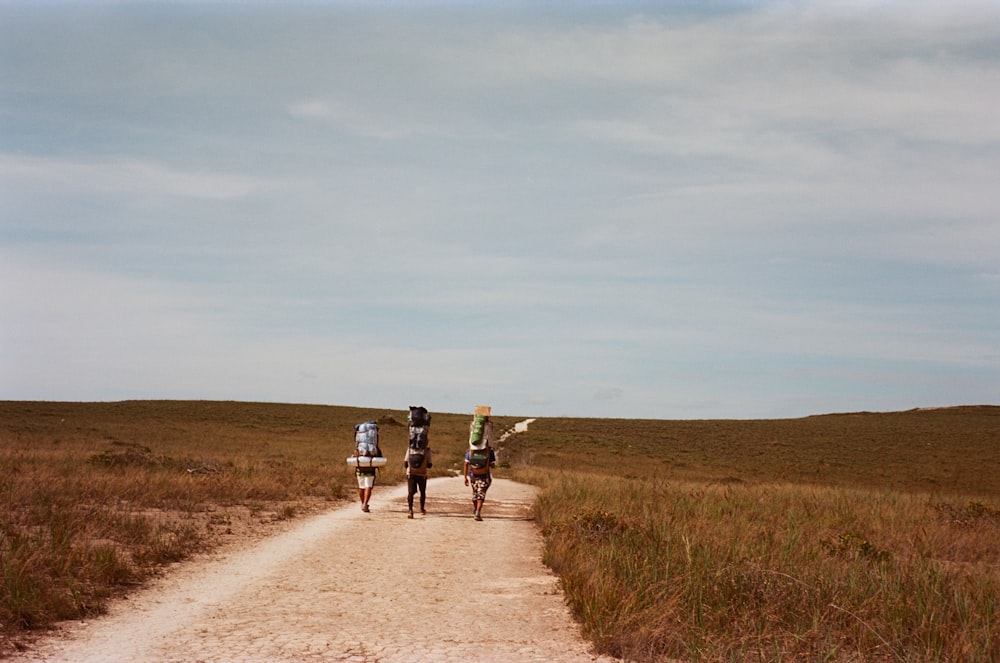 two people riding bikes down a dirt road