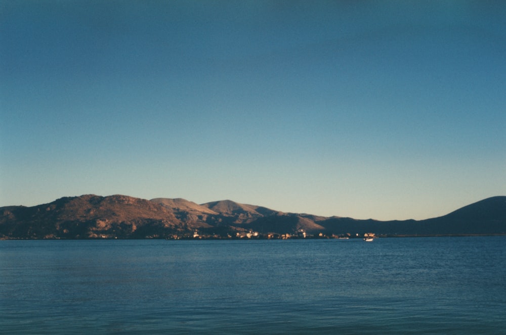 a body of water with mountains in the background