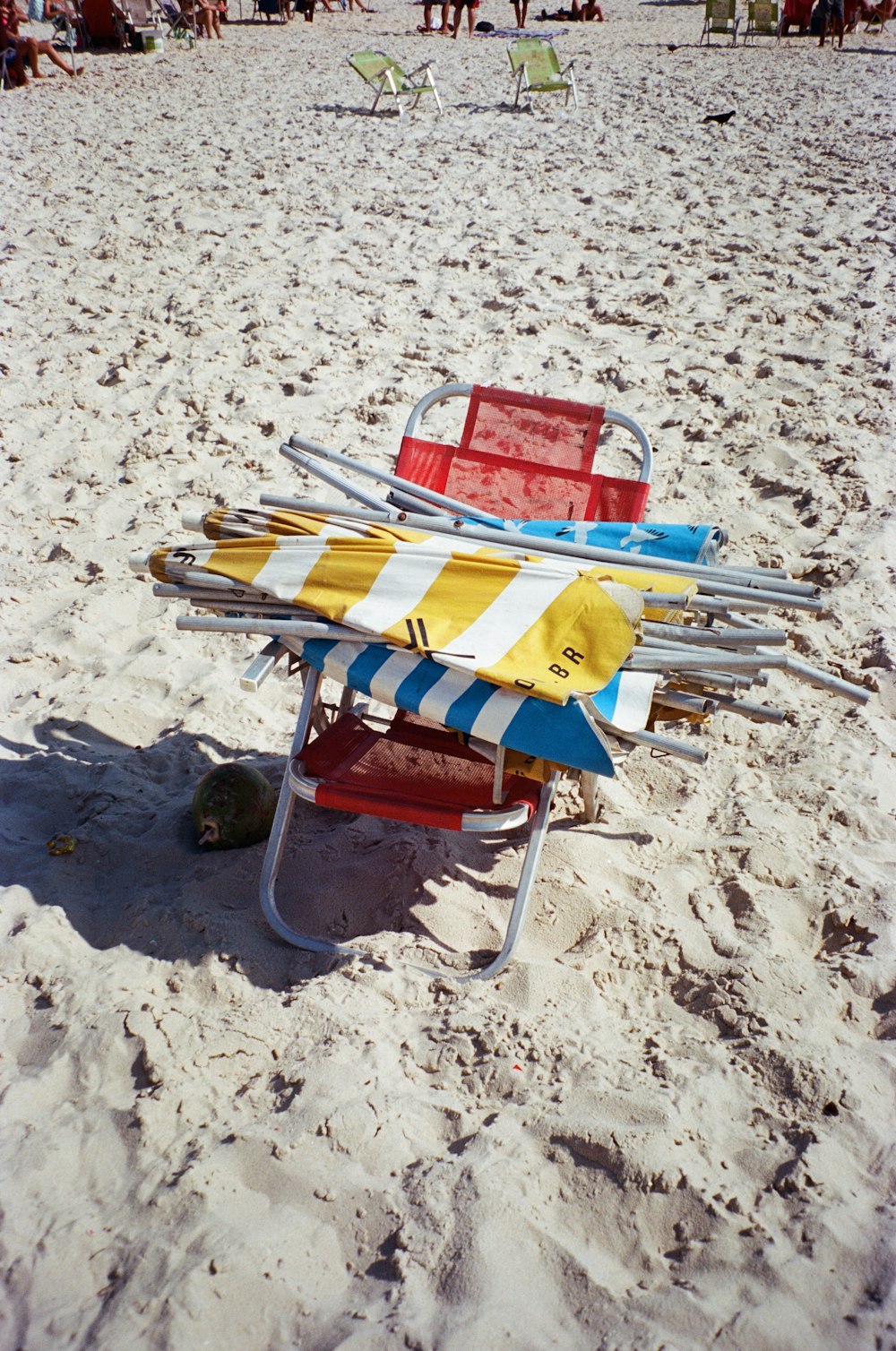a colorful beach chair sitting on top of a sandy beach