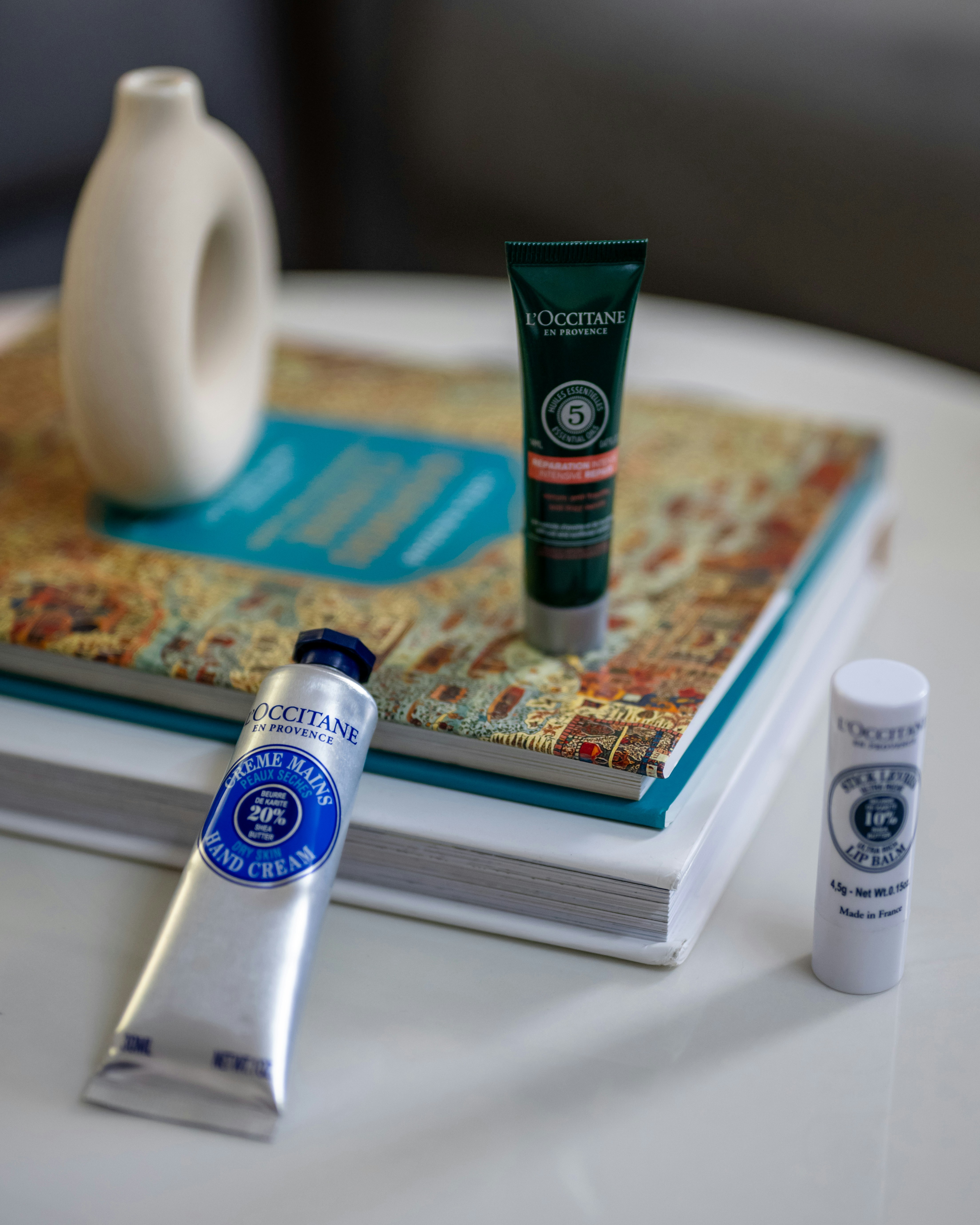 a table topped with a book and a white vase