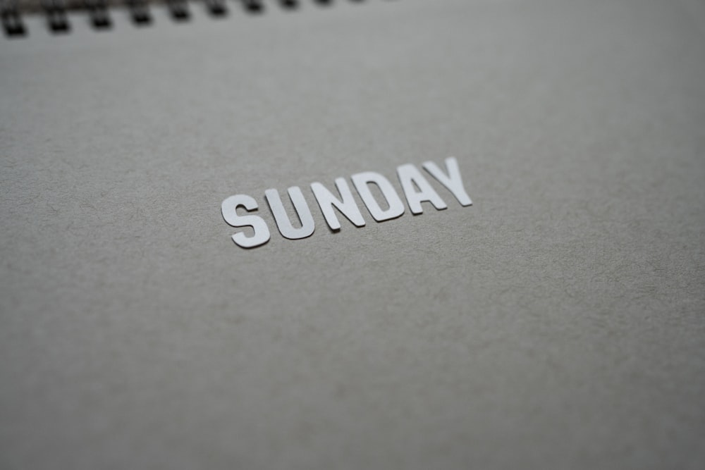 the word sunday is cut out of a notebook