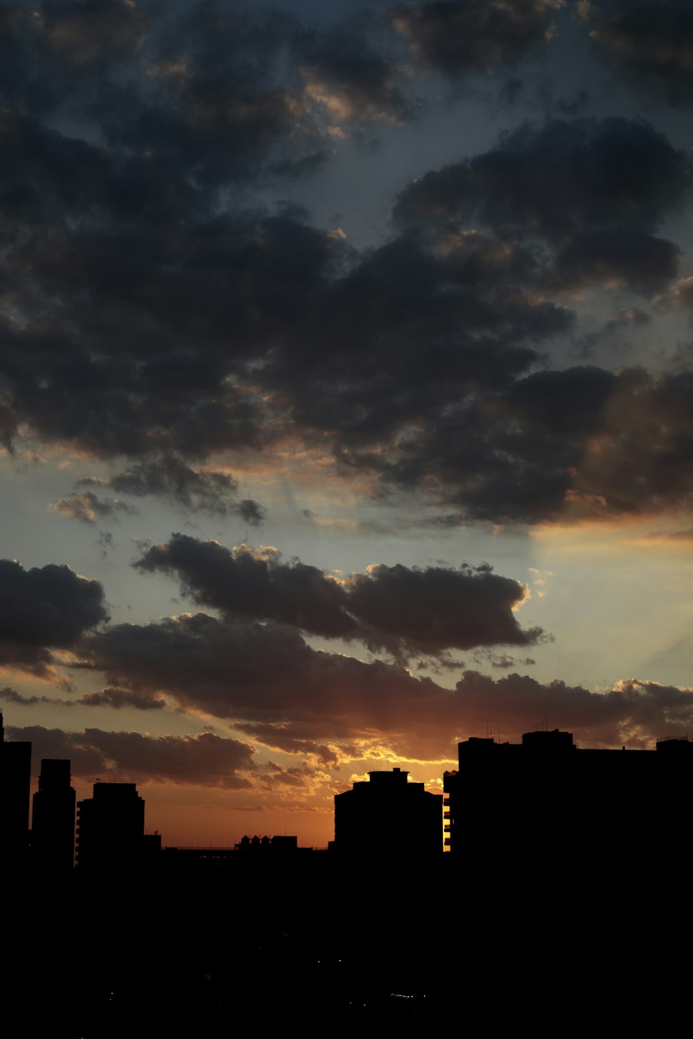 the sun is setting over a city with tall buildings