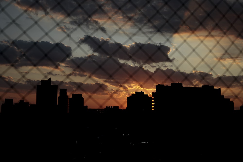 a view of a city through a chain link fence