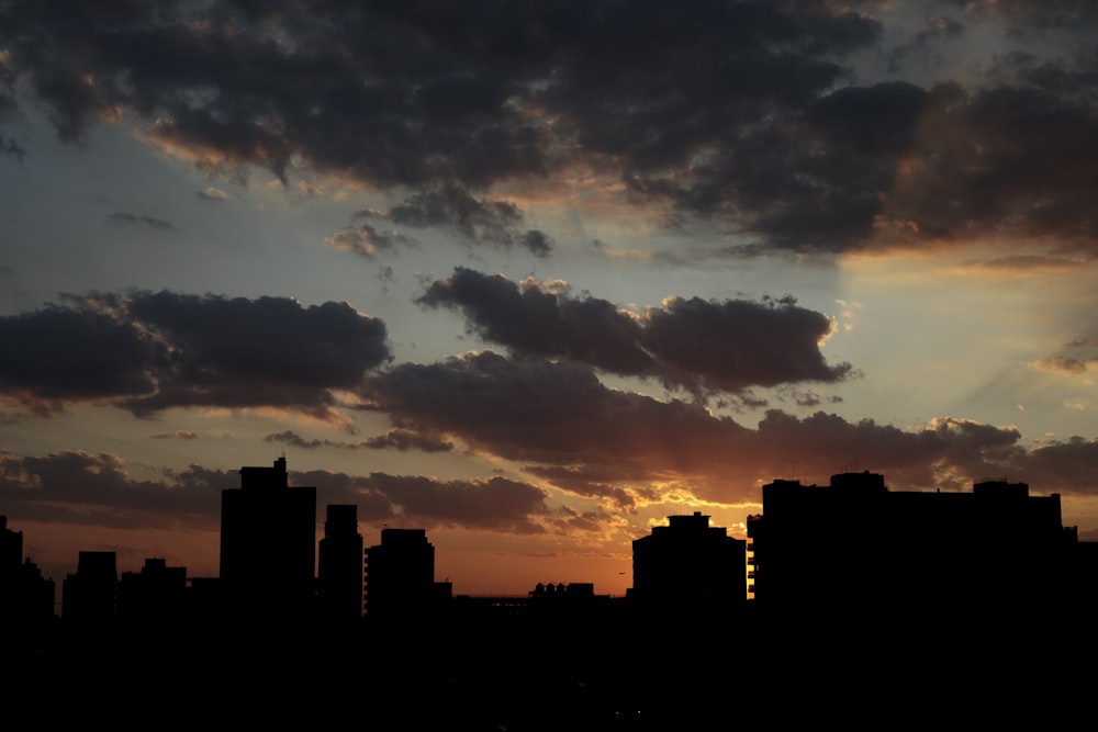 the sun is setting over a city with tall buildings