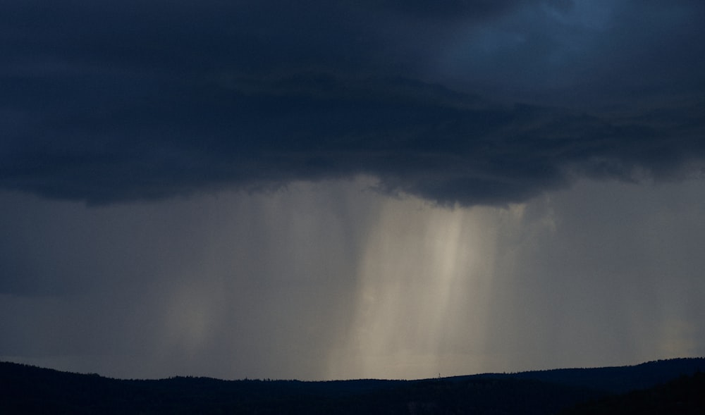 a dark sky with rain coming from the top of it