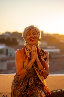 An elderly Indian woman smiling gratefully inside a cozy old age home in Mumbai.