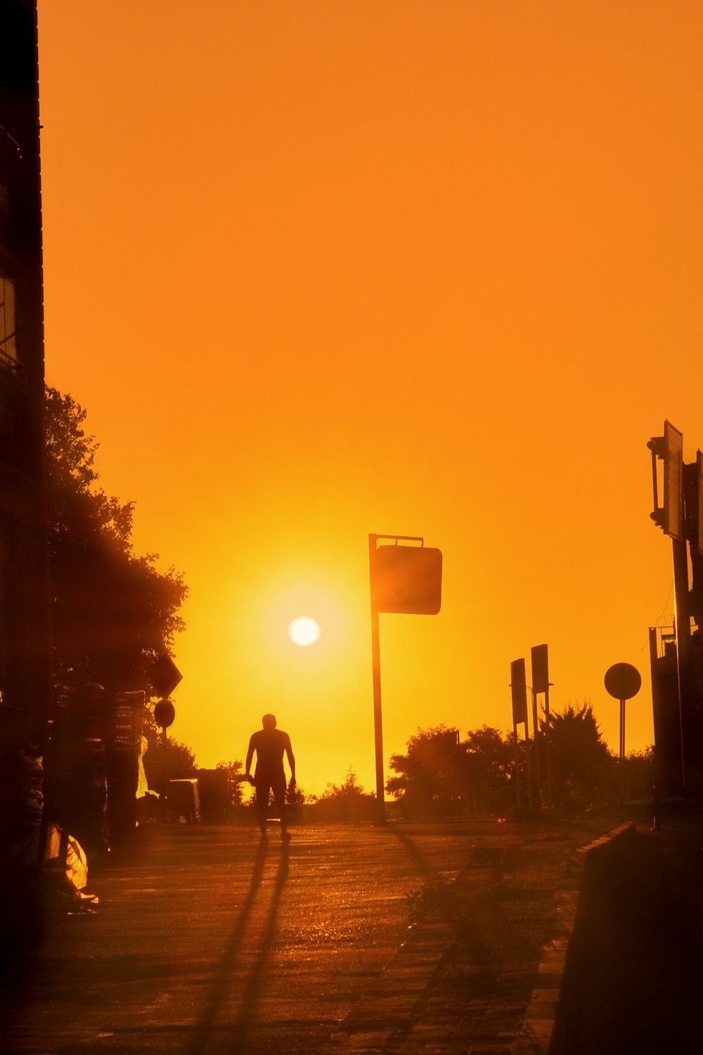 a person riding a bike down a street at sunset