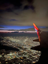Night view of Mumbai’s city lights with an airplane approaching.