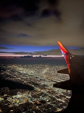 Long-haul flight view with city lights below at night