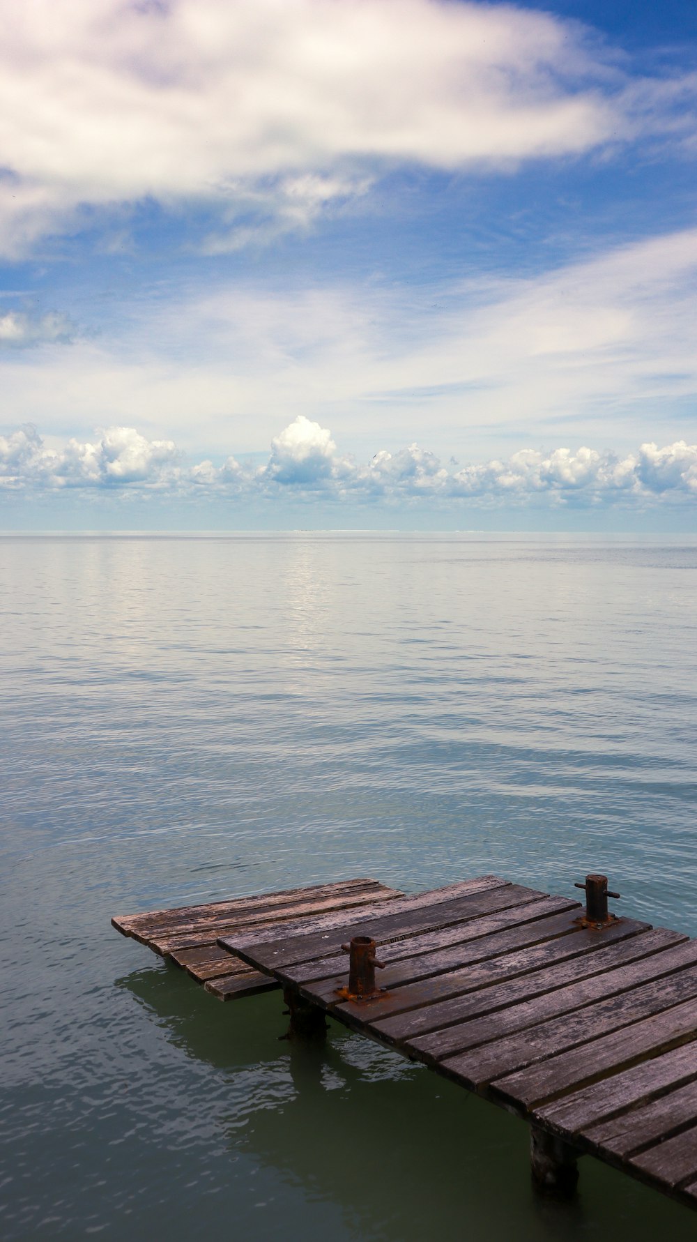 a wooden dock in the middle of a body of water