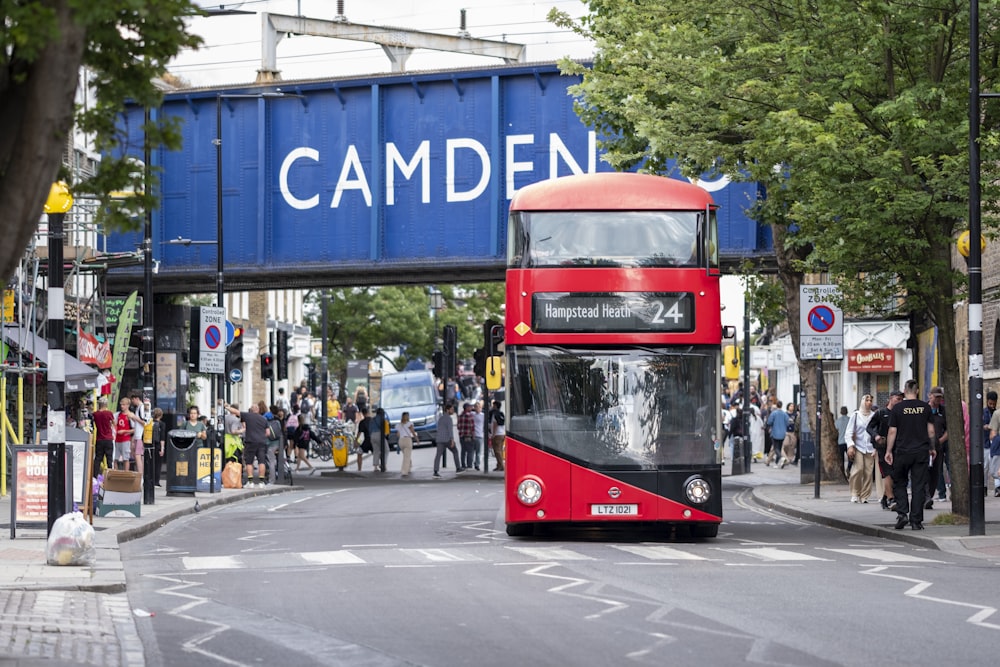 a red double decker bus driving down a street