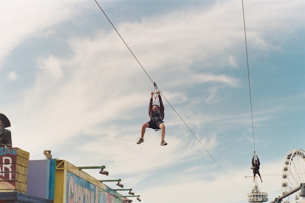 A group of excited tourists smiling and preparing for their zip-line experience in a tropical setting.