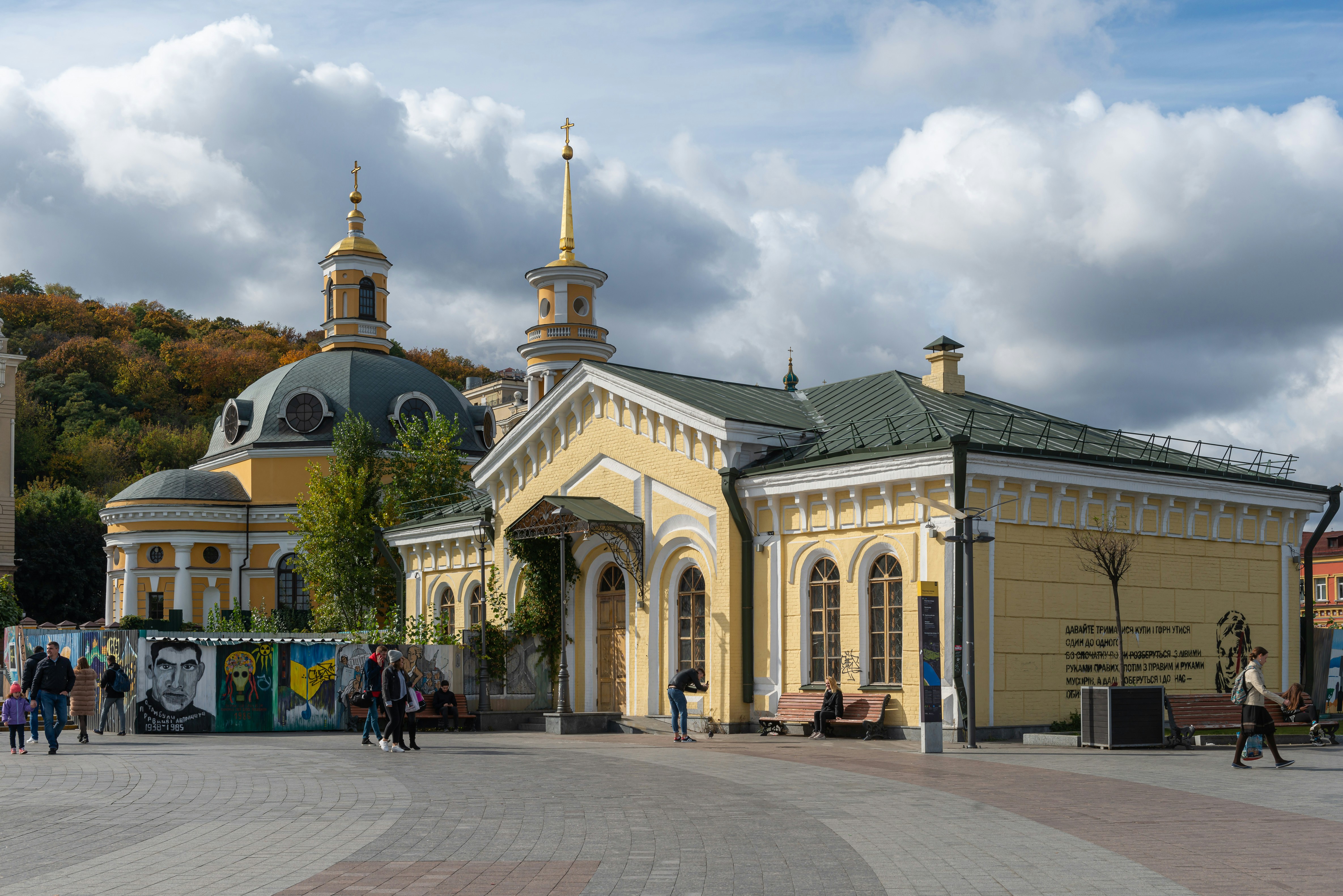 a large yellow building with a green roof