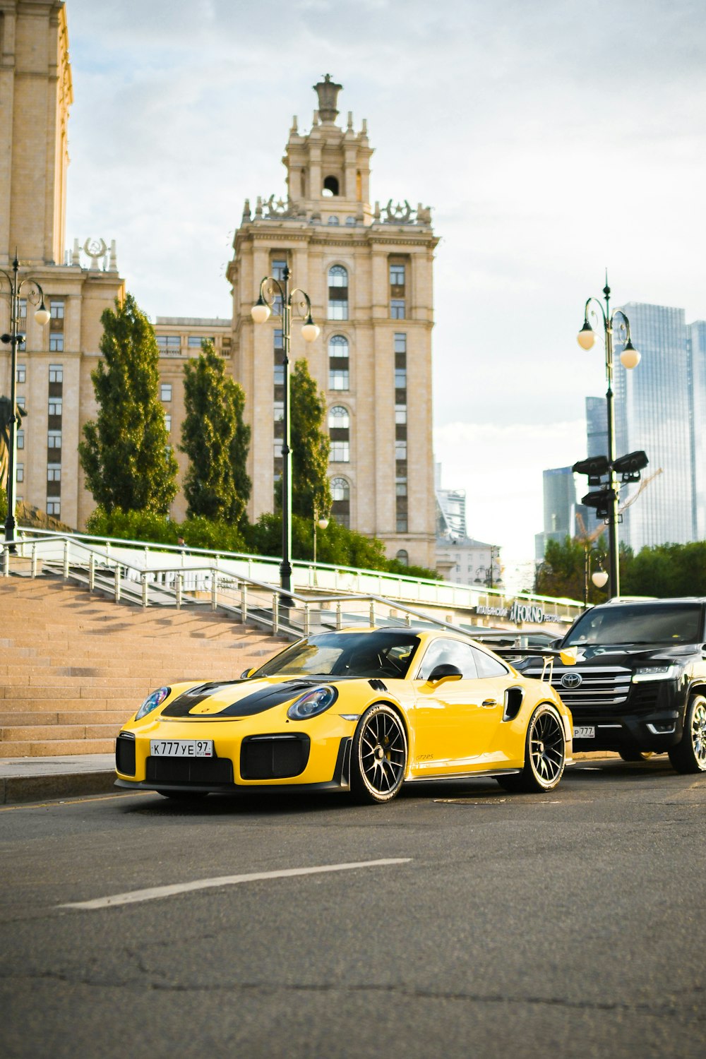 a yellow sports car parked next to a black sports car