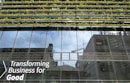 Glass-fronted building with reflections of the sky and nearby structures. Rows of greenery are integrated into the design above the windows. Large text on the building's facade reads 'Transforming Business for Good.'