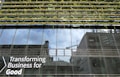 Glass-fronted building with reflections of the sky and nearby structures. Rows of greenery are integrated into the design above the windows. Large text on the building's facade reads 'Transforming Business for Good.'