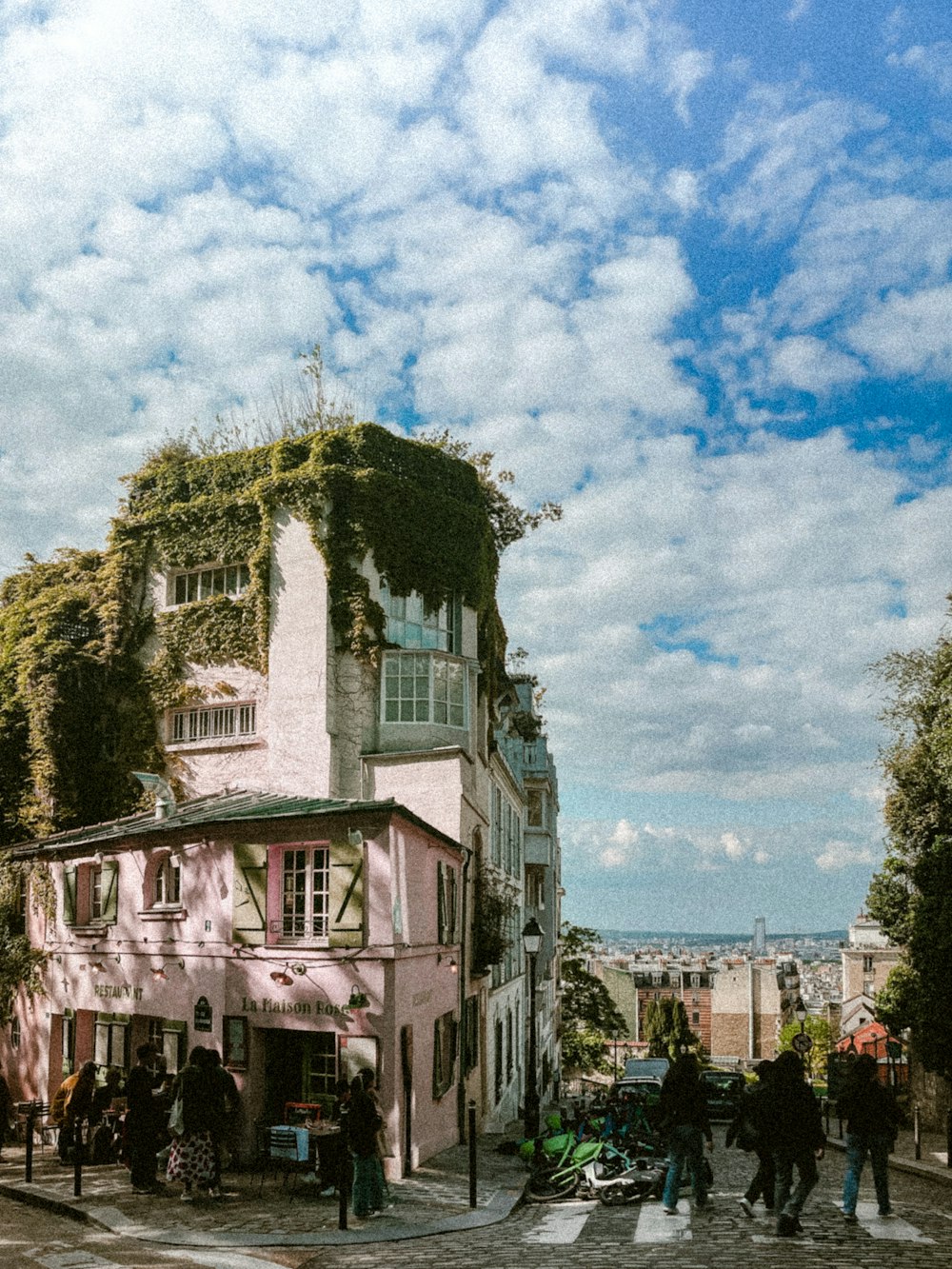 a group of people walking down a street next to a tall building