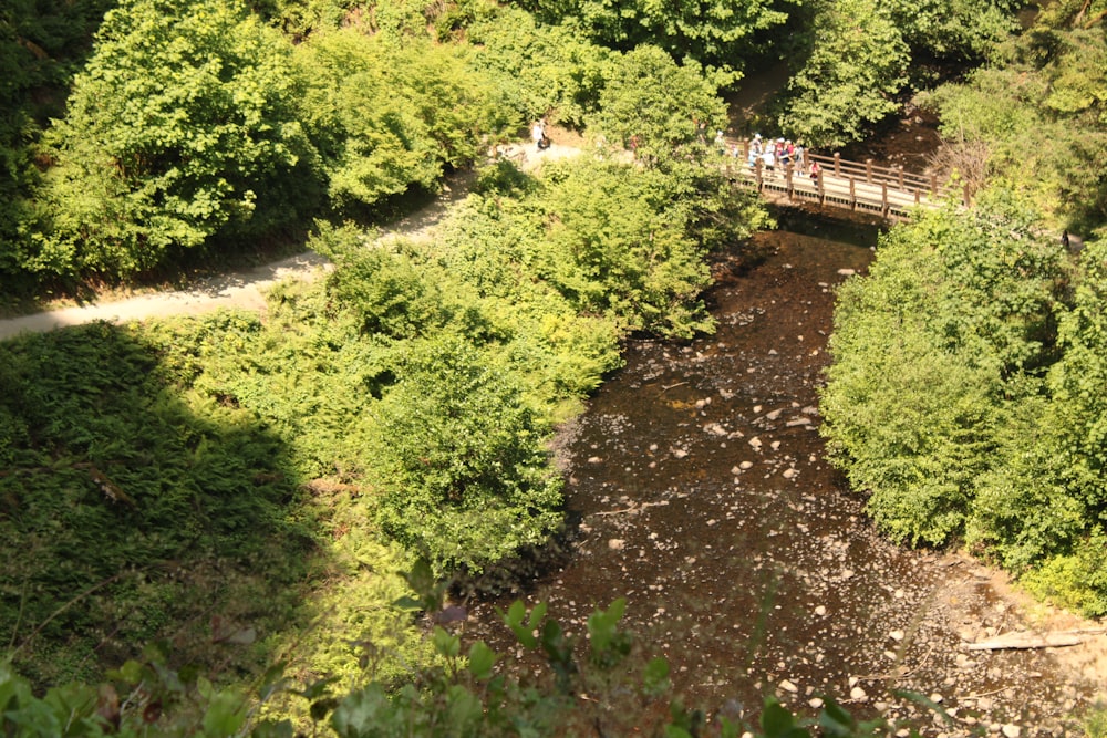 a group of people walking across a bridge over a river