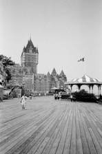 A black-and-white historical photo of the house surrounded by people from different eras, capturing its rich past.