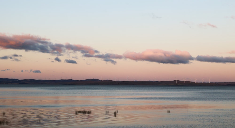 a large body of water with some clouds in the sky