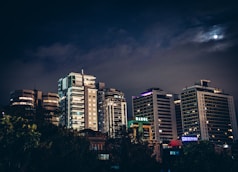 a city at night with a full moon in the sky