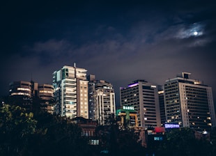 a city at night with a full moon in the sky