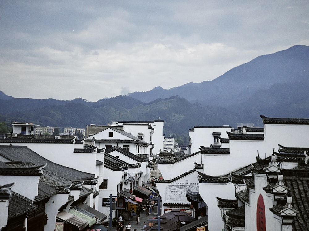 a group of buildings with mountains in the background