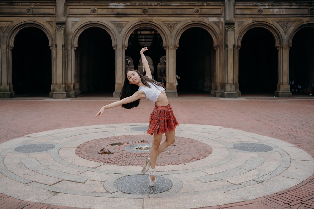 a woman in a red skirt is dancing in a circle