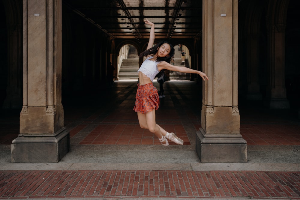 a woman is jumping in the air in a building