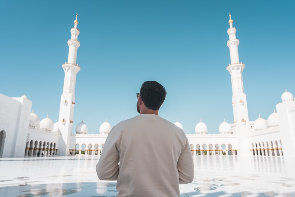 a man standing in front of a white building