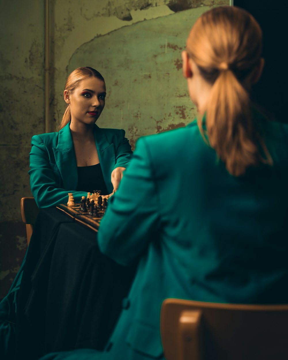 a woman sitting at a table playing a game of chess