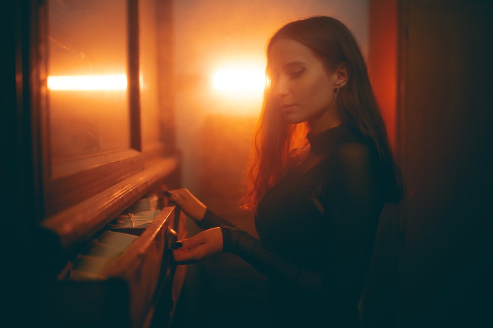 a woman standing in front of a window at night