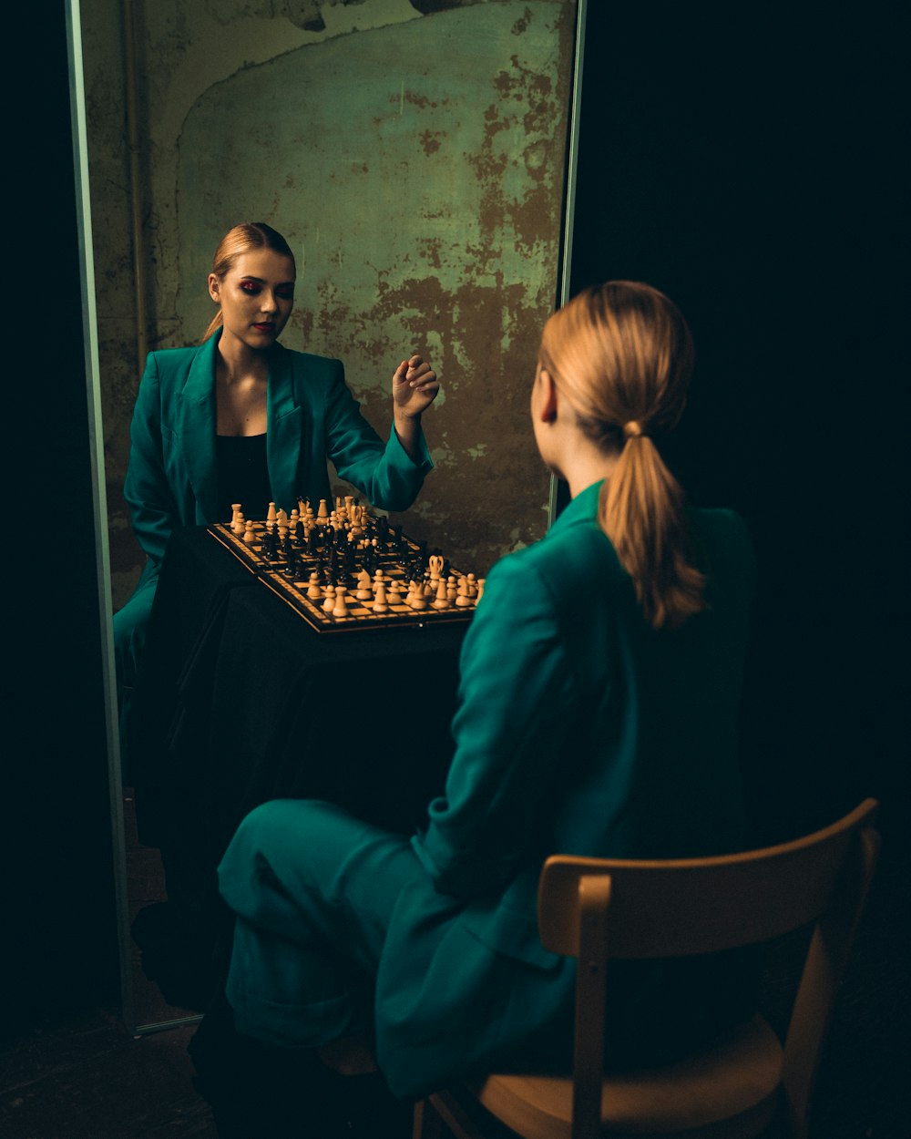 two women sitting at a table playing chess