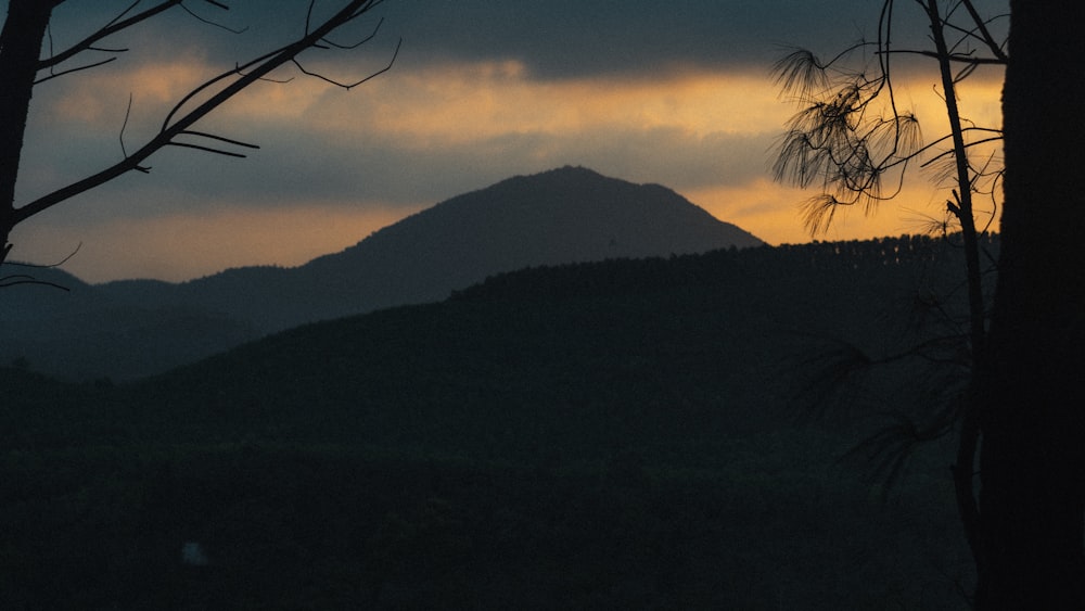 the sun is setting behind a mountain range