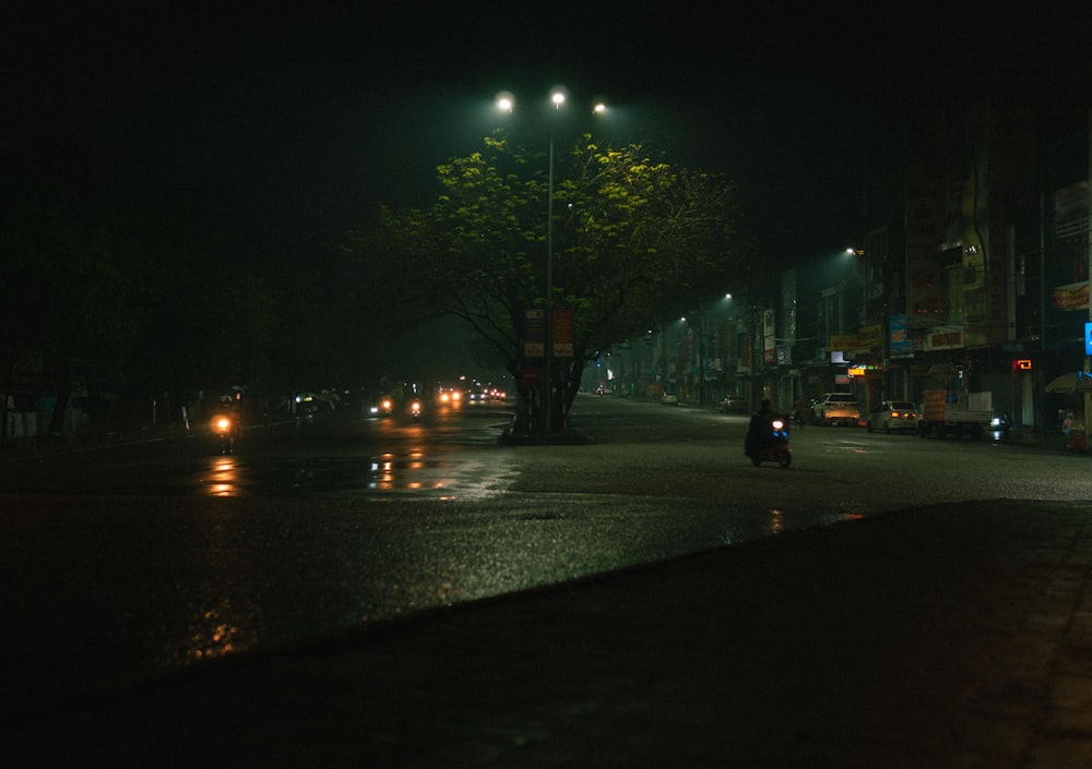 a person riding a motorcycle down a street at night