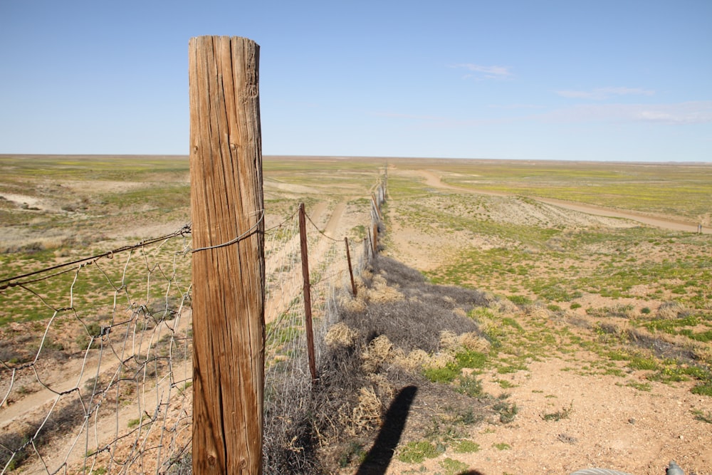 a wooden fence in the middle of a field