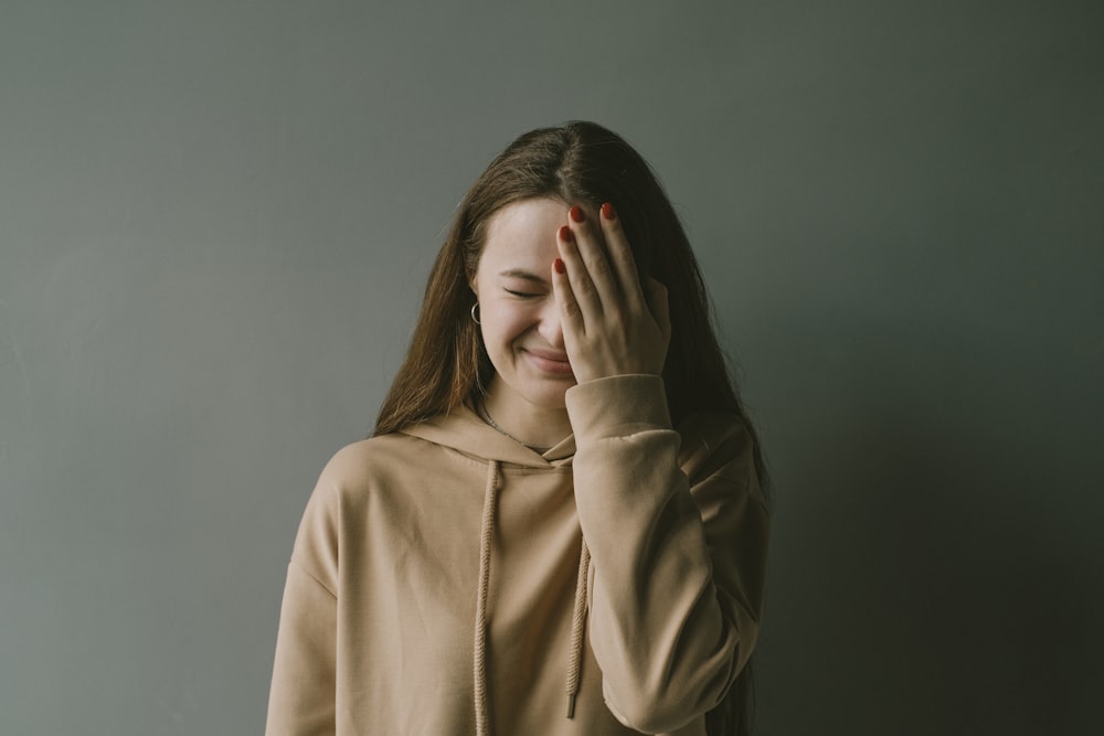 a woman covering her face with her hands