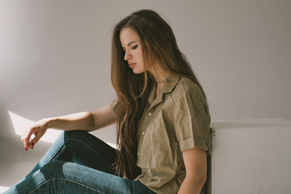 a woman sitting on the floor looking at a laptop