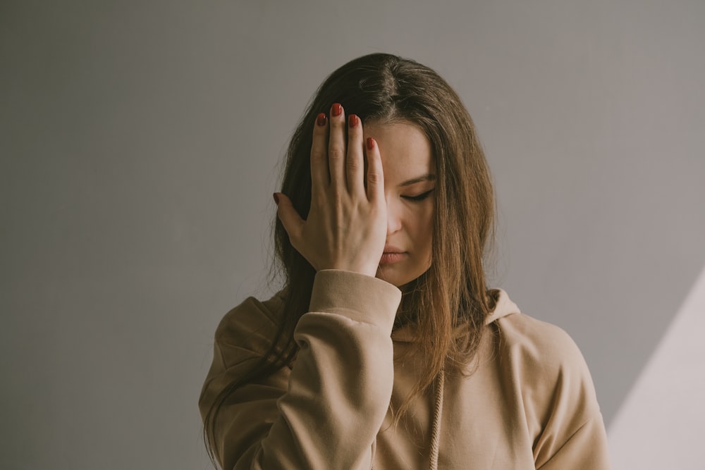 a woman covering her face with her hands