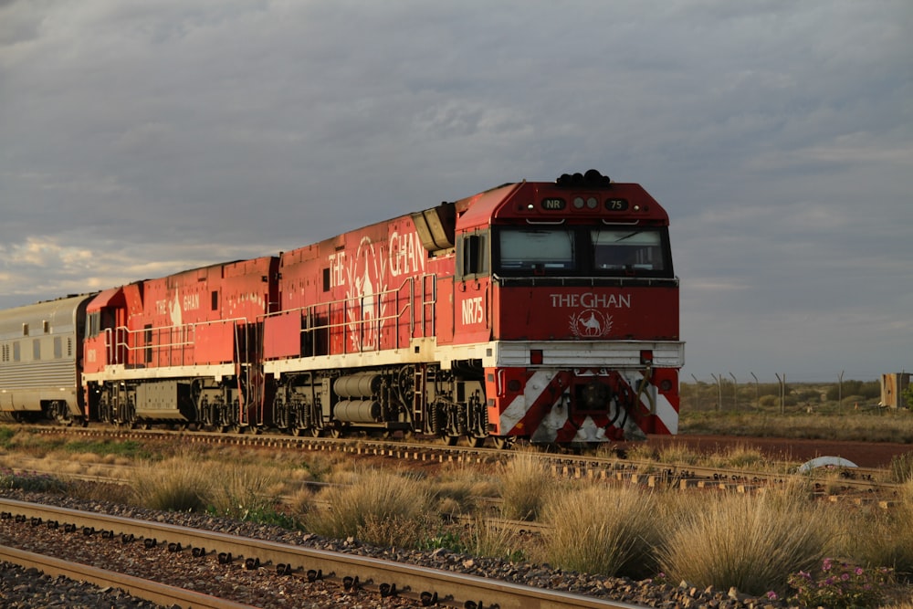 a red and white train traveling down train tracks