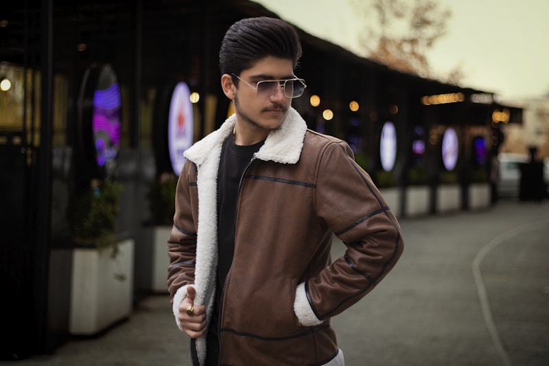 a man wearing a brown jacket and sunglasses